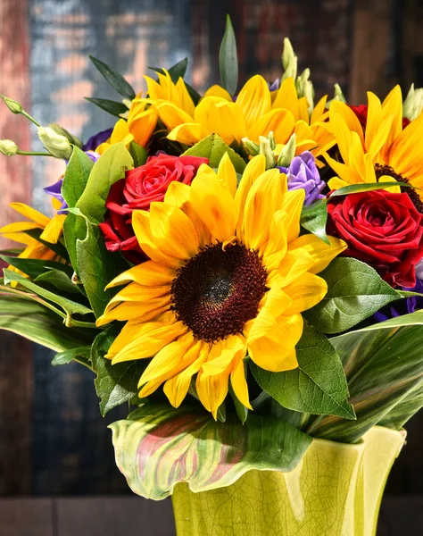 Composition with bouquet of flowers including sunflowers and roses