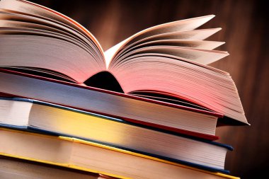 Masanın üzerinde kitaplar olan kompozisyon.