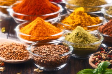 Mutfak masasında çeşitli baharat ve bitkiler var..