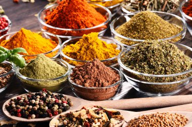 Mutfak masasında çeşitli baharat ve bitkiler var..