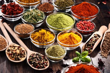 Mutfak masasında çeşitli baharat ve bitkiler var..