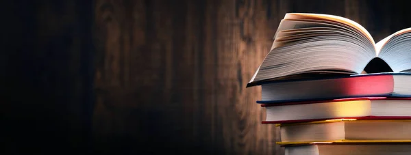 Masanın üzerinde kitaplar olan kompozisyon.