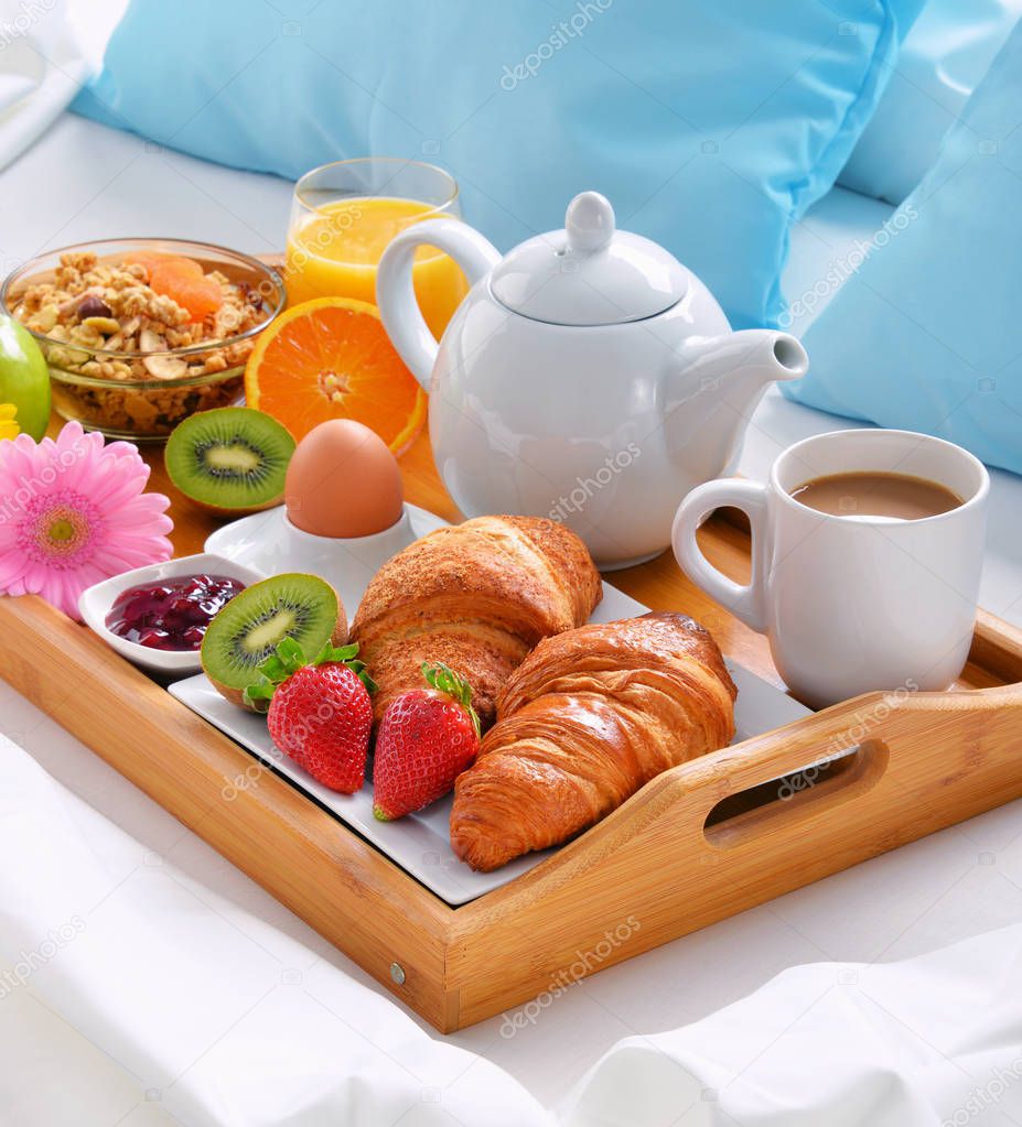 Breakfast tray in bed in hotel room. 