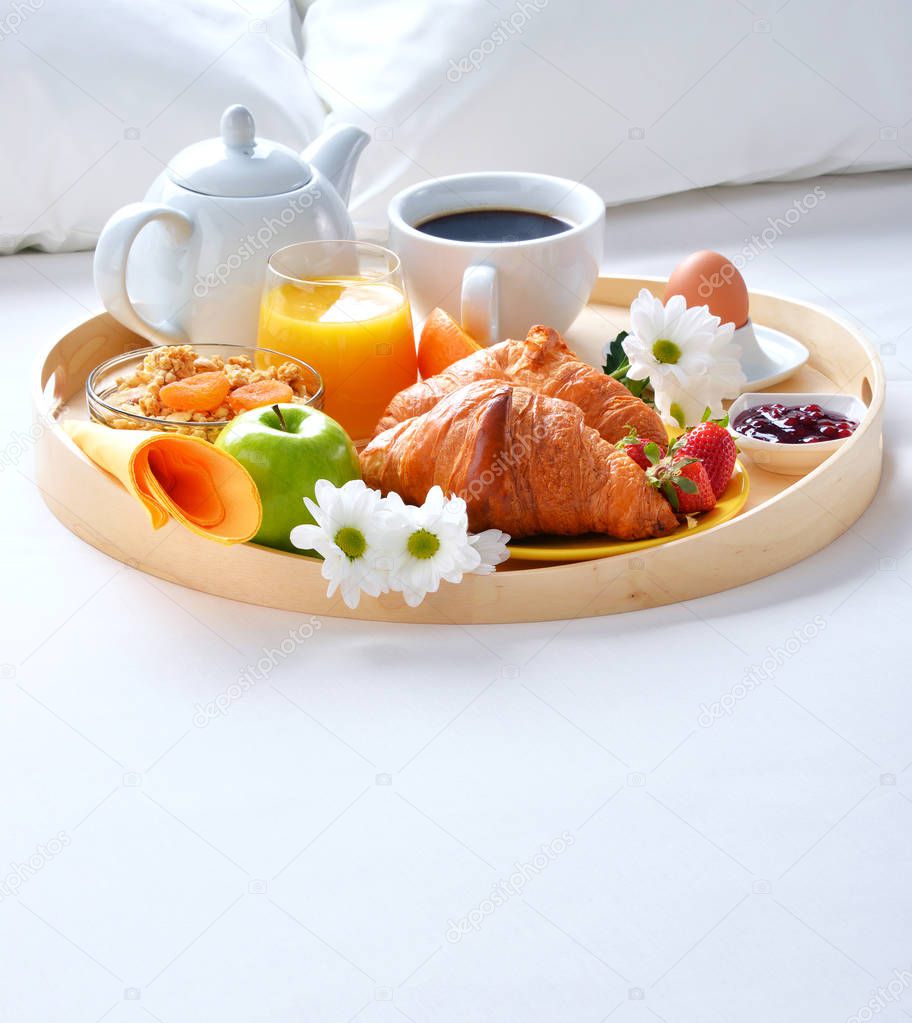 Breakfast tray in bed in hotel room. 