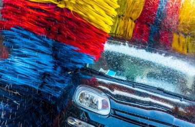 Otomatik oto yıkama makinesinden geçen araba..