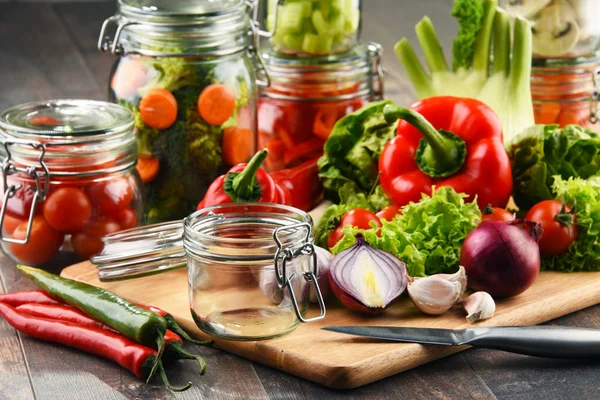 Gläser Mit Mariniertem Essen Und Rohem Gemüse Auf Schneidebrett — Stockfoto