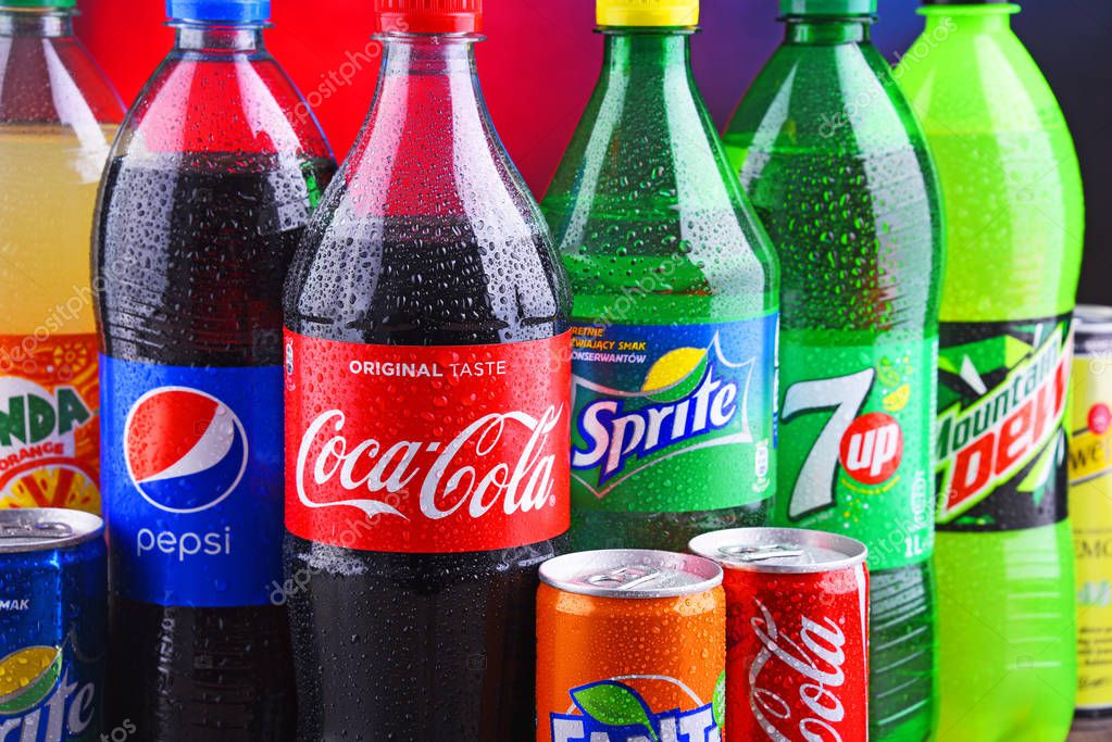 POZNAN, POLAND - NOV 16, 2018: Bottles and cans of global soft drink brands including products of Coca Cola Company and Pepsico