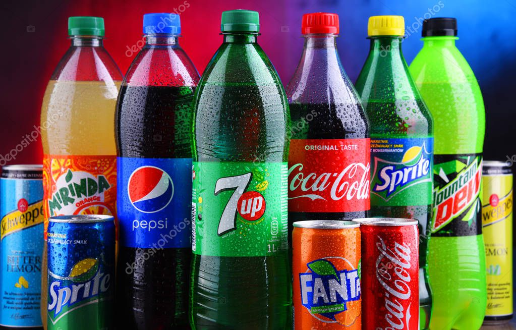 POZNAN, POLAND - NOV 16, 2018: Bottles and cans of global soft drink brands including products of Coca Cola Company and Pepsico