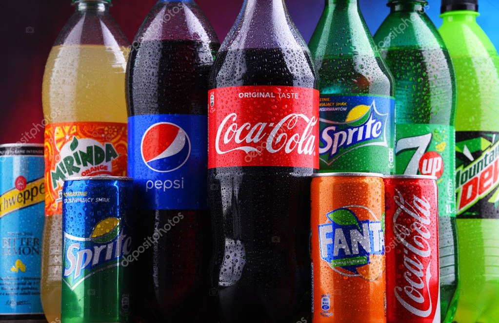 POZNAN, POLAND - NOV 16, 2018: Bottles and cans of global soft drink brands including products of Coca Cola Company and Pepsico