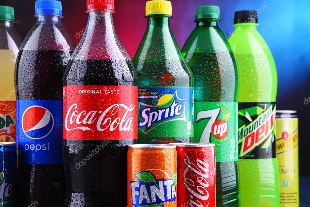 POZNAN, POLAND - NOV 16, 2018: Bottles and cans of global soft drink brands including products of Coca Cola Company and Pepsico