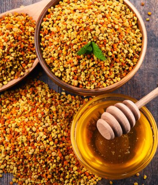 Arı polen ve bal mutfak masasında ile kase. Beslenme takviyeleri