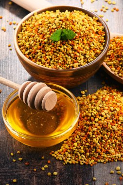 Arı polen ve bal mutfak masasında ile kase. Beslenme takviyeleri