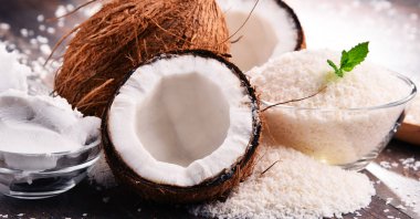 Ahşap masa üzerinde parçalanmış hindistan cevizi ve kabuklu kompozisyon