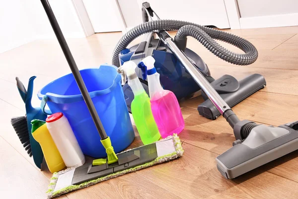 真空吸尘器和各种洗涤剂瓶和化学清洗用品在地板上 — 图库照片