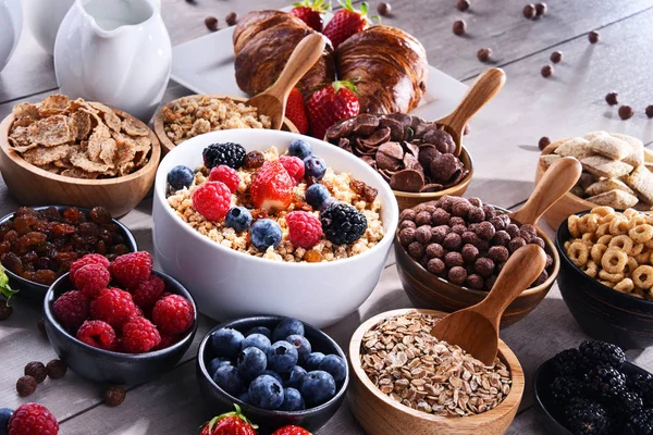 Composition with different sorts of breakfast cereal products and fresh fruits.