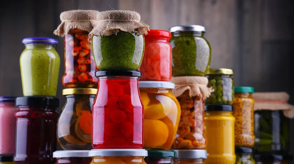 Gläser mit verschiedenen eingelegten Gemüsen und Früchten — Stockfoto