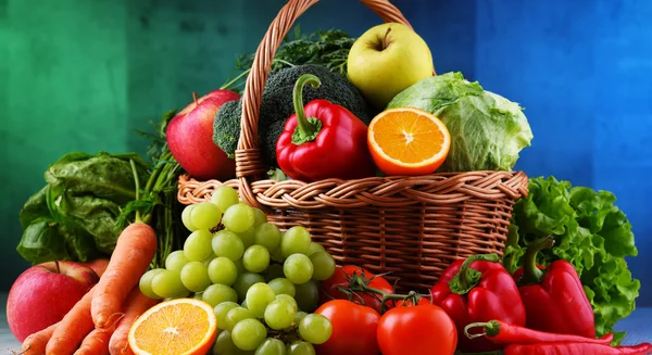 Fresh organic fruits and vegetables in wicker basket — Stock Photo, Image