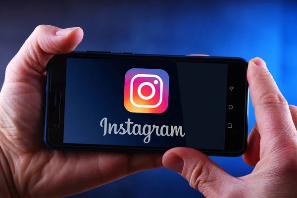 Manos sosteniendo el logotipo del teléfono inteligente que muestra Instagram —  Fotos de Stock