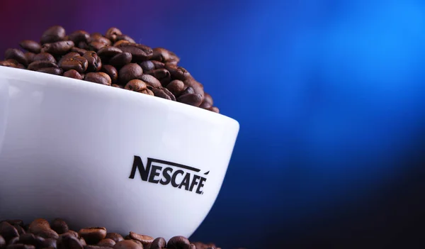 Samenstelling met kop Nescafe koffie bonen — Stockfoto