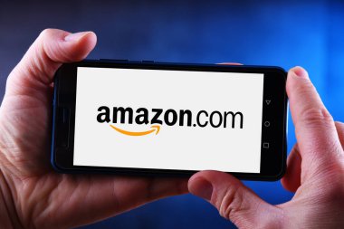 Amazon logosunu gösteren akıllı telefonu tutan eller