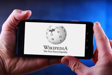 Wikipedia logosu gösteren Hands tutarak akıllı telefon