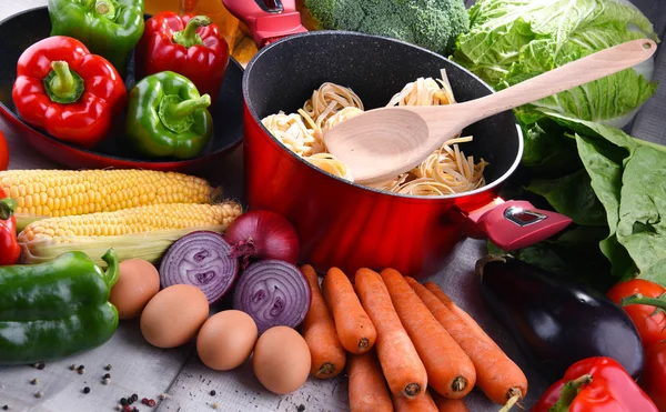 Свежие овощи и варочный чайник на кухонном столе — стоковое фото