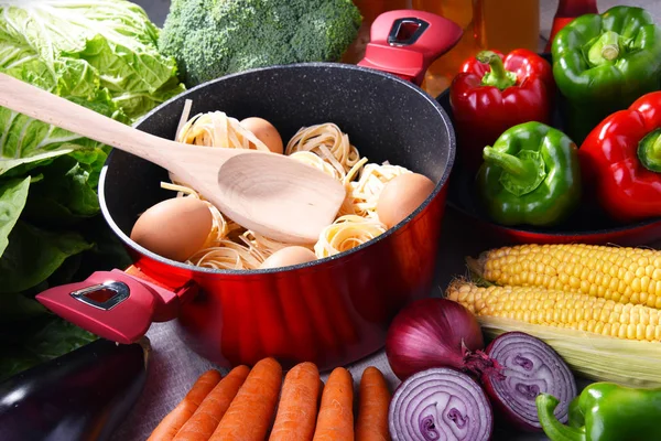Verse groenten en kookpot op keuken tafel — Stockfoto