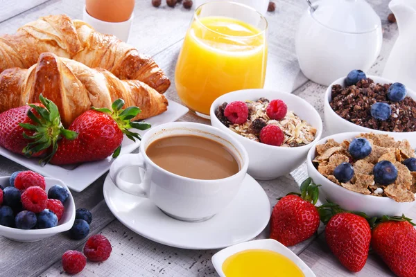 Café da manhã servido com café, suco, croissants e frutas — Fotografia de Stock