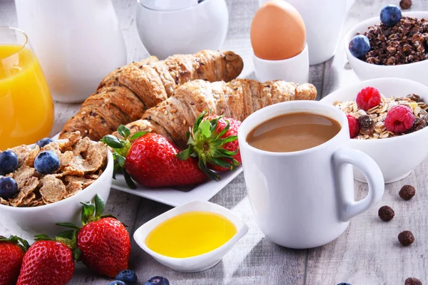 Café da manhã servido com café, suco, croissants e frutas — Fotografia de Stock