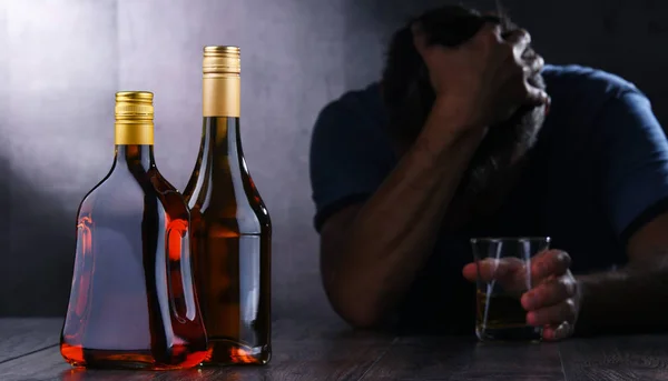 Бутылки с алкогольными напитками и фигура пьяного мужчины — стоковое фото