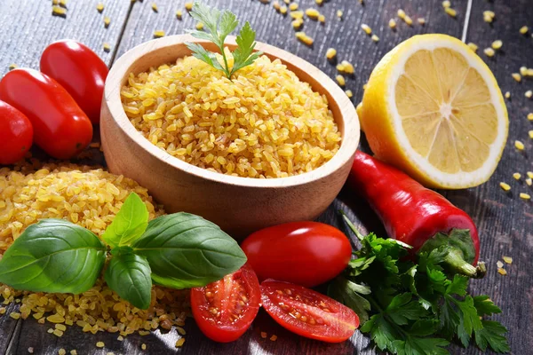 Tigela de bulgur não cozido na mesa de madeira — Fotografia de Stock