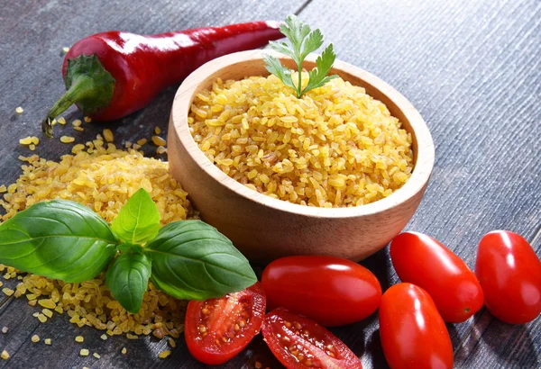 Tigela de bulgur não cozido na mesa de madeira — Fotografia de Stock