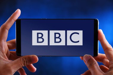 Bbc logosunu gösteren akıllı telefonu tutan eller