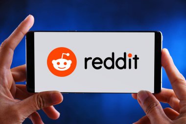 Reddit logosunu gösteren akıllı telefonu tutan eller