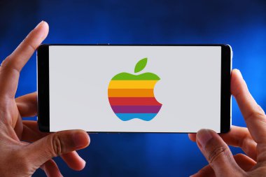 Apple'ın logosunu gösteren akıllı telefonu tutan eller