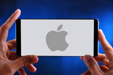 Apple'ın logosunu gösteren akıllı telefonu tutan eller