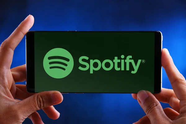 Χέρια που κρατούν smartphone που εμφανίζει το λογότυπο του Spotify — Φωτογραφία Αρχείου