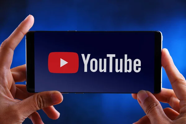 Manos sosteniendo el logotipo del smartphone de YouTube —  Fotos de Stock