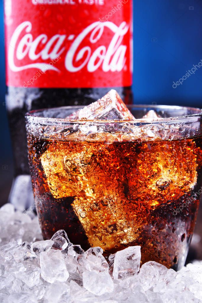 POZNAN, POL - AUG 13, 2019: A bottle and a glass of Coca-Cola, a carbonated soft drink manufactured by The Coca-Cola Company headquartered in Atlanta, Georgia, USA