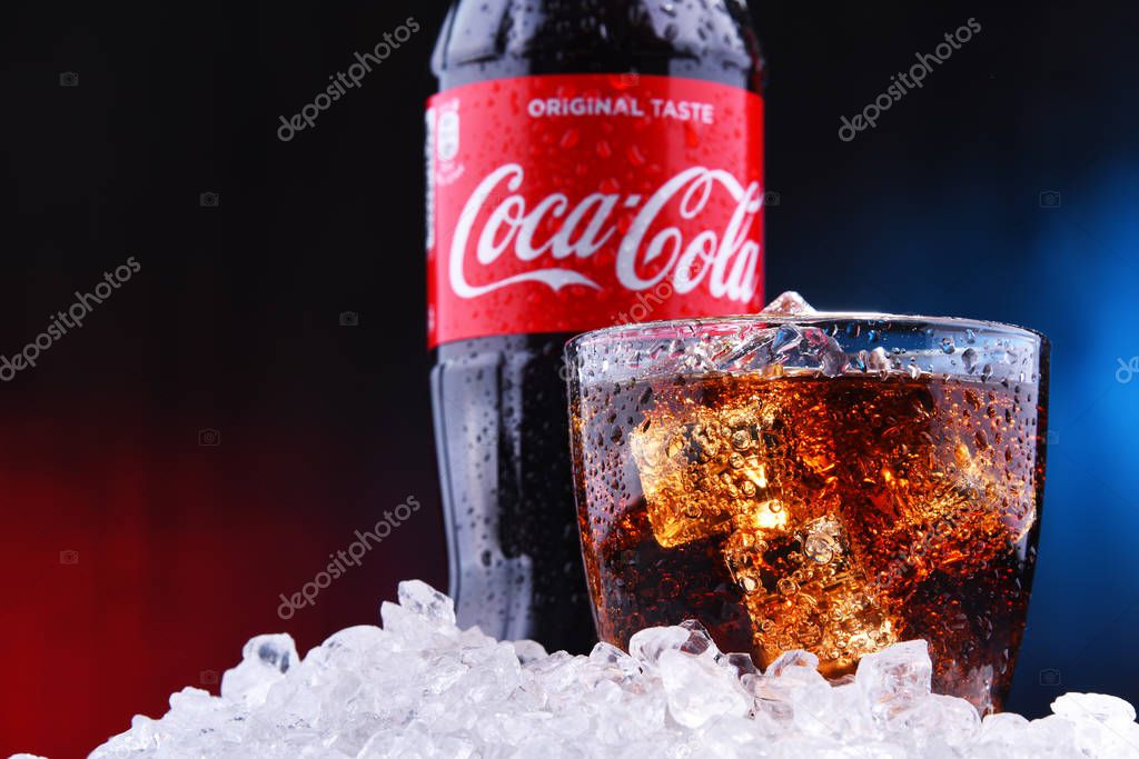 POZNAN, POL - AUG 13, 2019: A bottle and a glass of Coca-Cola, a carbonated soft drink manufactured by The Coca-Cola Company headquartered in Atlanta, Georgia, USA