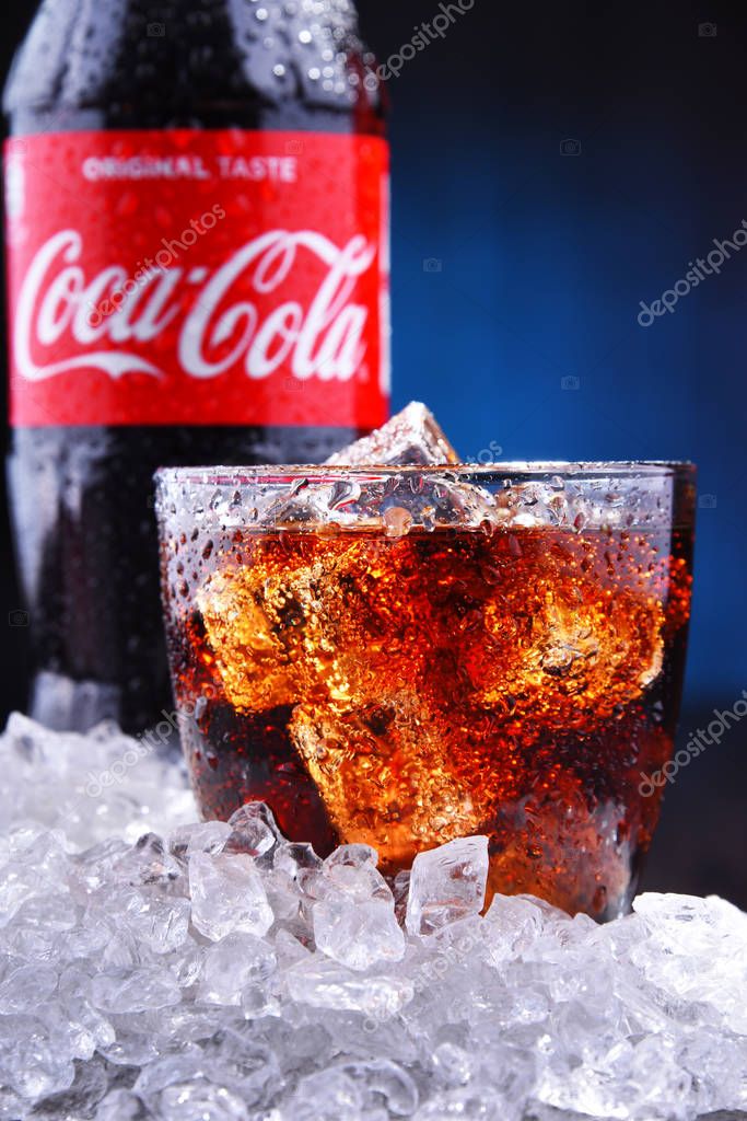 POZNAN, POL - AUG 13, 2019: A bottle and a glass of Coca-Cola, a carbonated soft drink manufactured by The Coca-Cola Company headquartered in Atlanta, Georgia, USA