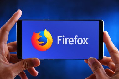 Firefox logosunu gösteren akıllı telefonu tutan eller