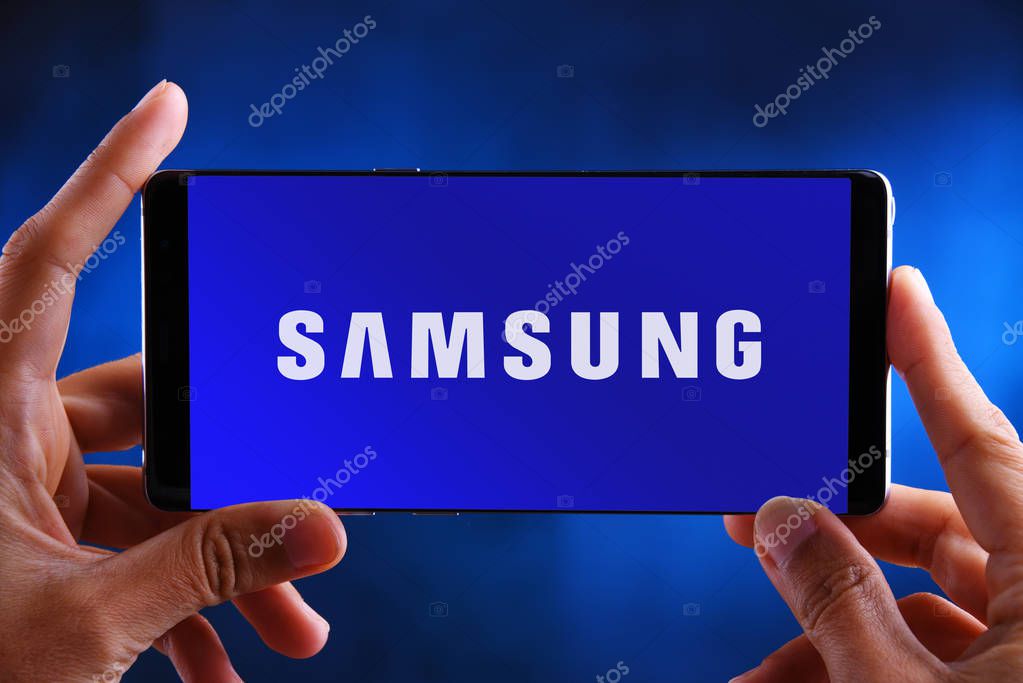 POZNAN, POL - JUL 10, 2019: Hands holding smartphone displaying logo of Samsung, a South Korean multinational conglomerate headquartered in Samsung Town, Seoul