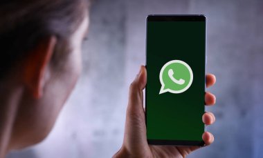 Whatsapp Messenger logosunu gösteren akıllı telefon tutan kadın