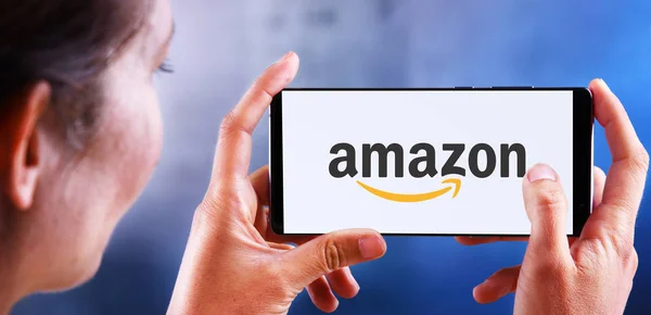 Mulher segurando smartphone exibindo logotipo da Amazon — Fotografia de Stock