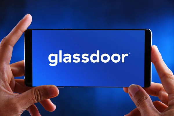 Manos sosteniendo el teléfono inteligente que muestra el logotipo de Glassdoor — Foto de Stock