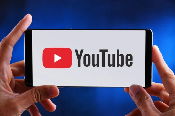 Manos sosteniendo el logotipo del smartphone de YouTube —  Fotos de Stock