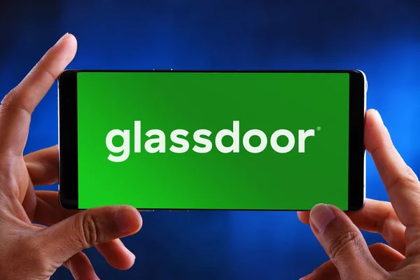 Manos sosteniendo el teléfono inteligente que muestra el logotipo de Glassdoor —  Fotos de Stock