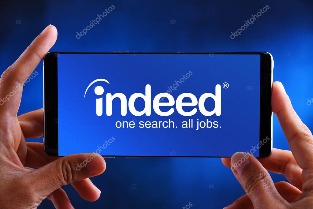 POZNAN, POL - JUL 10, 2019: Hands holding smartphone displaying logo of Indeed is an American worldwide employment-related search engine for job listings