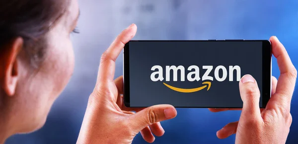 Nő gazdaság okostelefon megjelenítő logó az Amazon — Stock Fotó